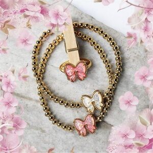 Kendra Scott Haley Bow Gold Stretch Bracelet featuring a custom-carved pink bow
